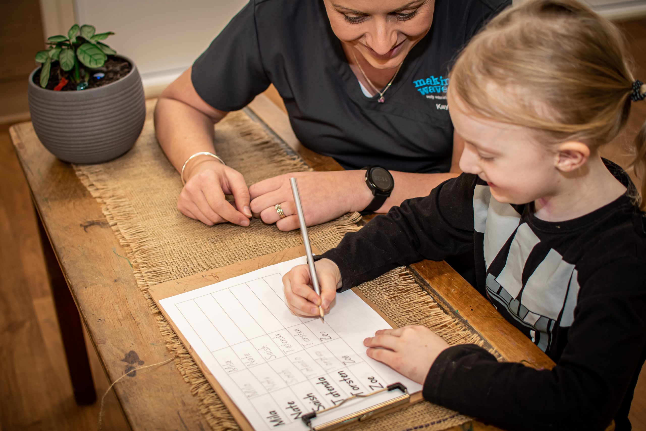 Educator helping child write